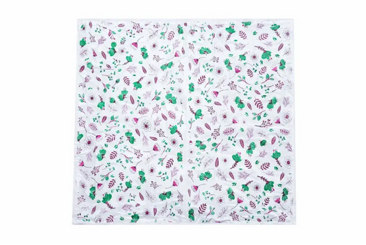 White square scarf with green and pink floral motifs shown with elite disposable table sheets sufra roll for food serving