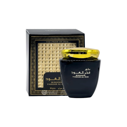 Black perfume bottle with gold cap and decorative box on a white background