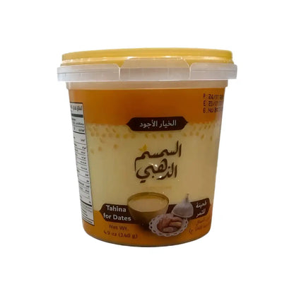 A yellow and white plastic container of golden sesame tahina for dates with arabic text and premium dates image label
