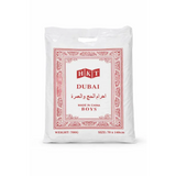 White plastic bag with red ornate border and hkt dubai branding containing boys clothing for umrah complete essentials set with digital tasbih and activity book