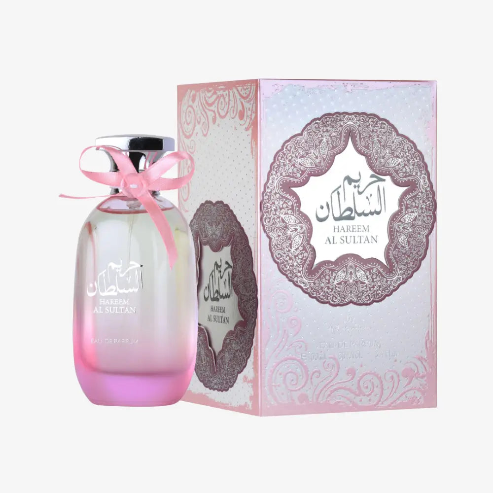 Pink gradient glass hareem al sultan perfume bottle with silver cap and pink ribbon beside ornate ard al zaafaran packaging floral touch