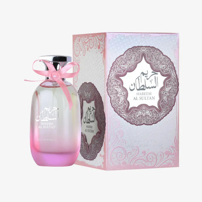 Pink gradient glass hareem al sultan perfume bottle with silver cap and pink ribbon beside ornate ard al zaafaran packaging floral touch