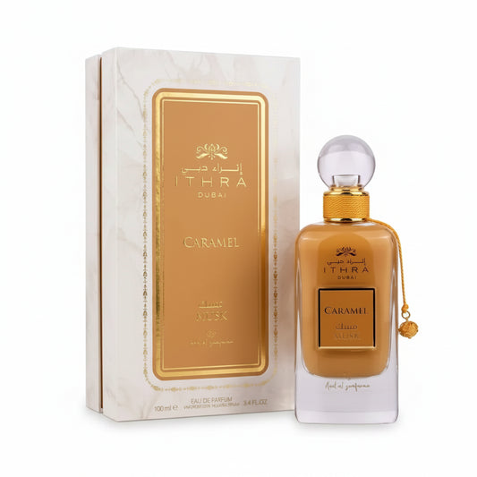 A golden-hued rectangular glass perfume bottle with a clear spherical cap for ithra dubai musk caramel eau de parfum