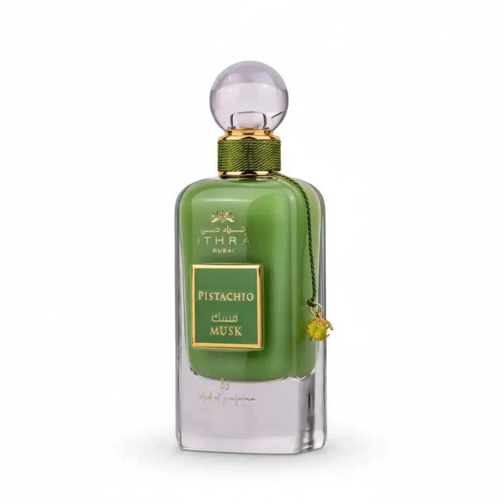 A sleek emerald green glass perfume bottle with gold accents labeled ithra dubai musk pistachio eau de parfum 100ml