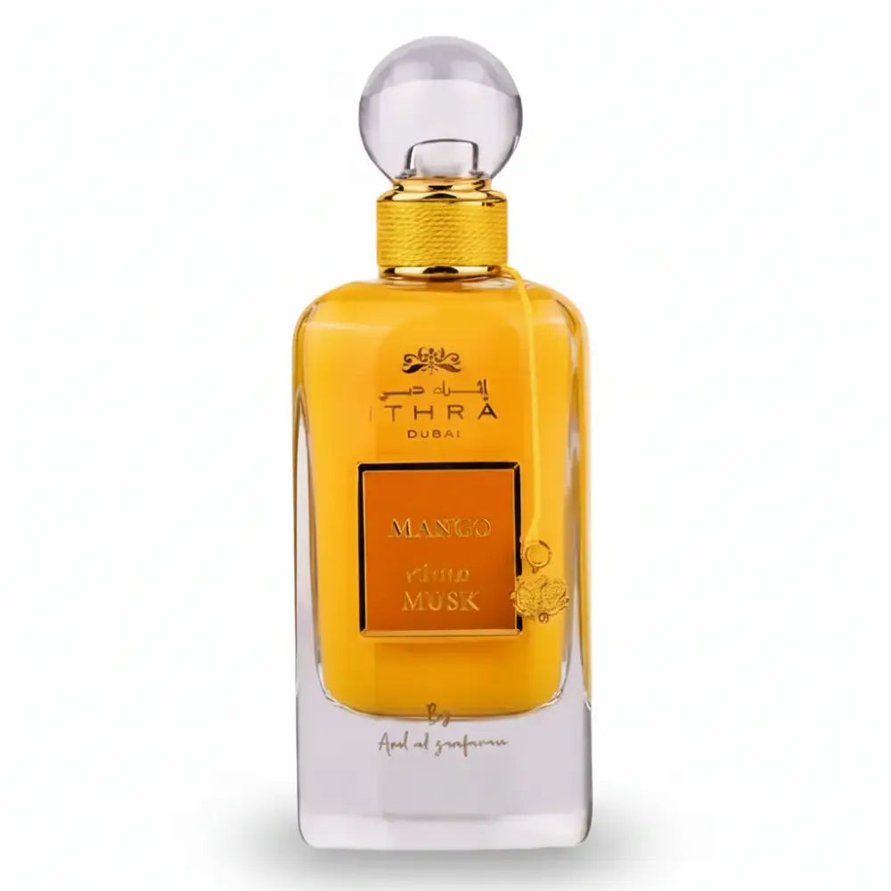 Golden-hued ithra dubai musk mango eau de parfum 100ml with clear glass body and ornate mango and musk label
