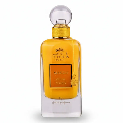 Golden-hued ithra dubai musk mango eau de parfum 100ml with clear glass body and ornate mango and musk label