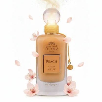 A sleek transparent glass perfume bottle with golden cap containing amber ithra dubai musk peach fragrance