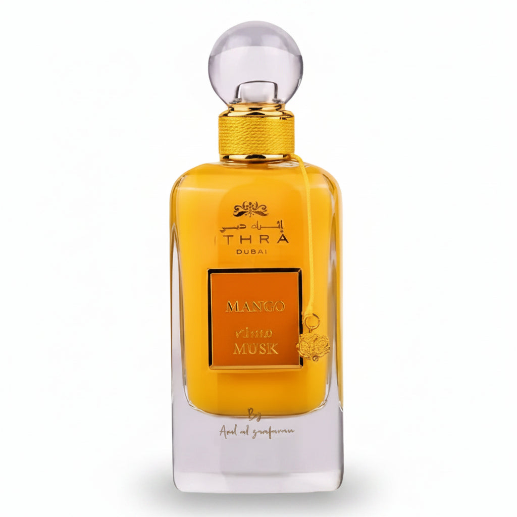 Golden-hued ithra dubai musk mango eau de parfum 100ml with clear glass body and ornate mango and musk label