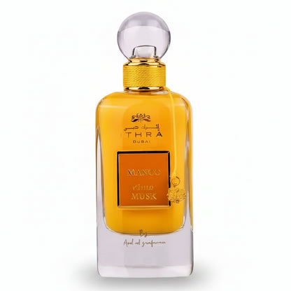Golden-hued ithra dubai musk mango eau de parfum 100ml with clear glass body and ornate mango and musk label