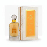 Golden-hued ithra dubai musk mango eau de parfum 100ml in clear glass bottle with gold cap beside marble box