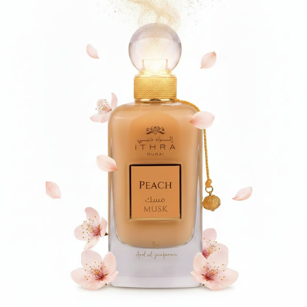 A sleek transparent glass perfume bottle with golden cap containing amber ithra dubai musk peach fragrance