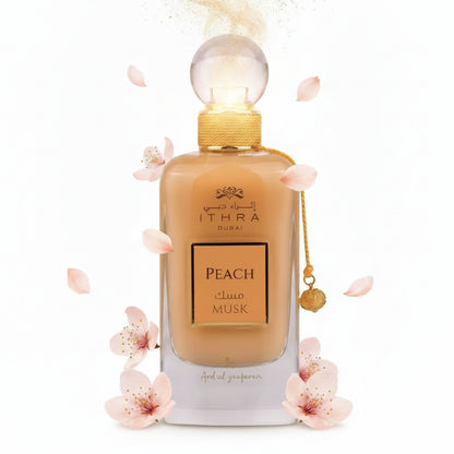 A sleek transparent glass perfume bottle with golden cap containing amber ithra dubai musk peach fragrance
