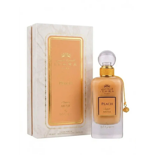 A sleek amber-hued ithra dubai musk peach eau de parfum 100ml with gold embossed label and clear glass stopper