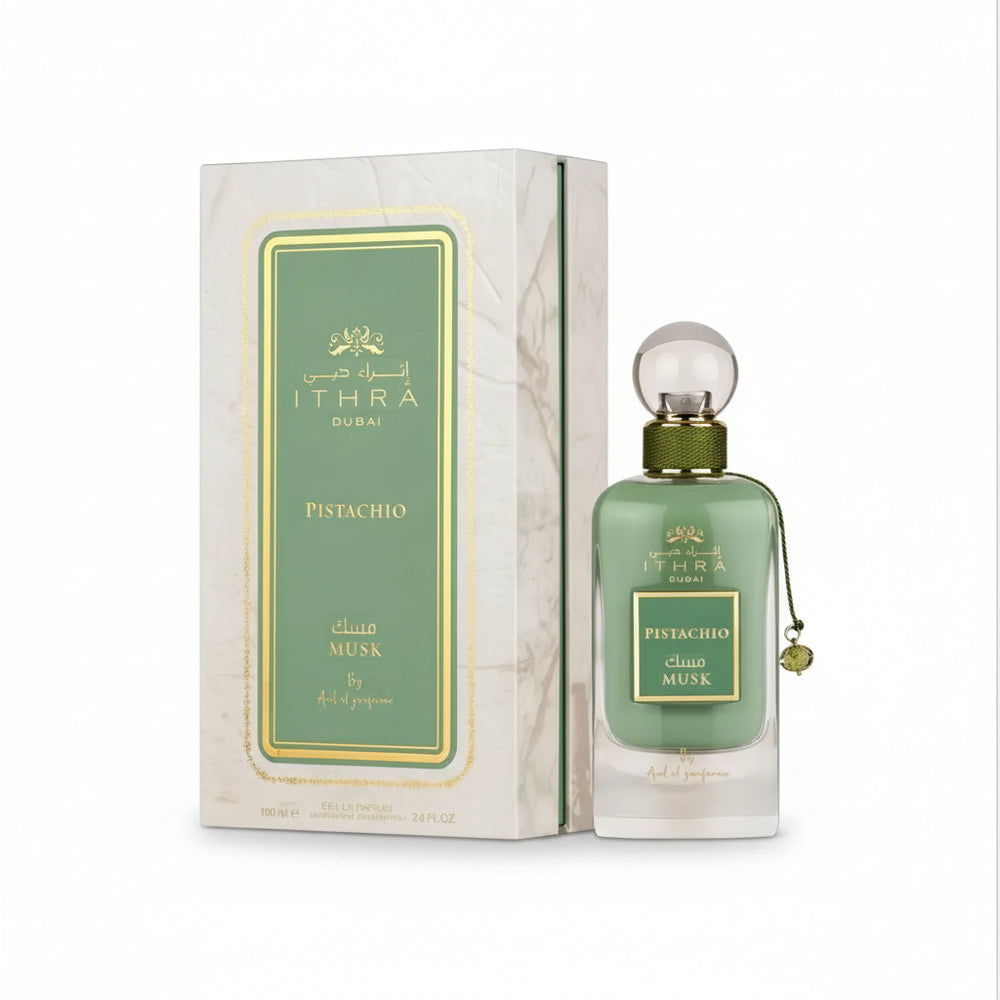 Green glass bottle of ithra dubai musk pistachio eau de parfum with gold cap and clear spherical stopper 100ml
