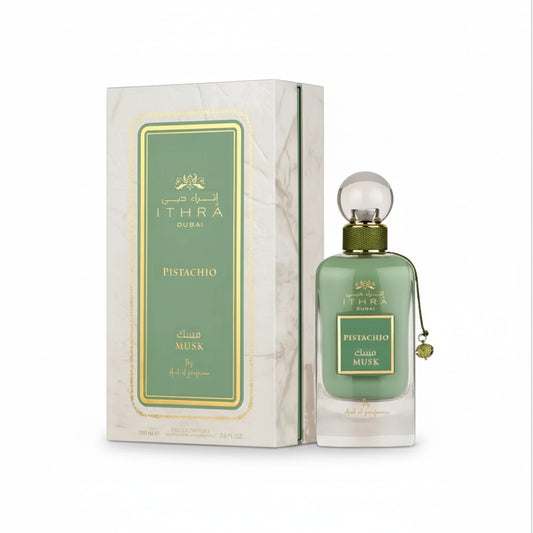 Green glass bottle of ithra dubai musk pistachio eau de parfum with gold cap and clear spherical stopper 100ml
