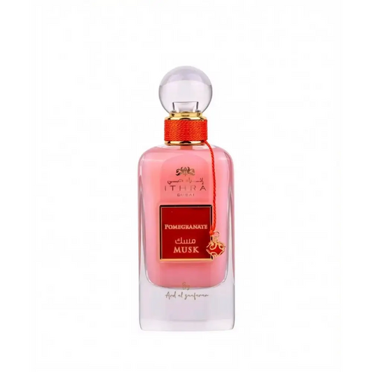 A pink glass perfume bottle of ithra dubai musk pomegranate eau de parfum 100ml with gold cap and red ribbon tie