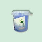 A blue plastic container of moroccan blue nila powder 30g with a clear lid labeled in arabic and green leaf imagery