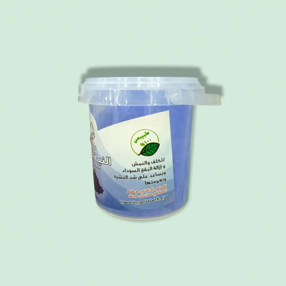 A blue plastic container of moroccan blue nila powder 30g with a clear lid labeled in arabic and green leaf imagery