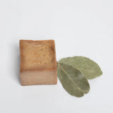 Bar of soap with a leaf on a light gray background