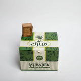 Green and white box with a brown bar of soap on top against a white background