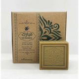 A square beige natural olive oil soap bar with an embossed floral design from mübarek oud and sandalwood collection