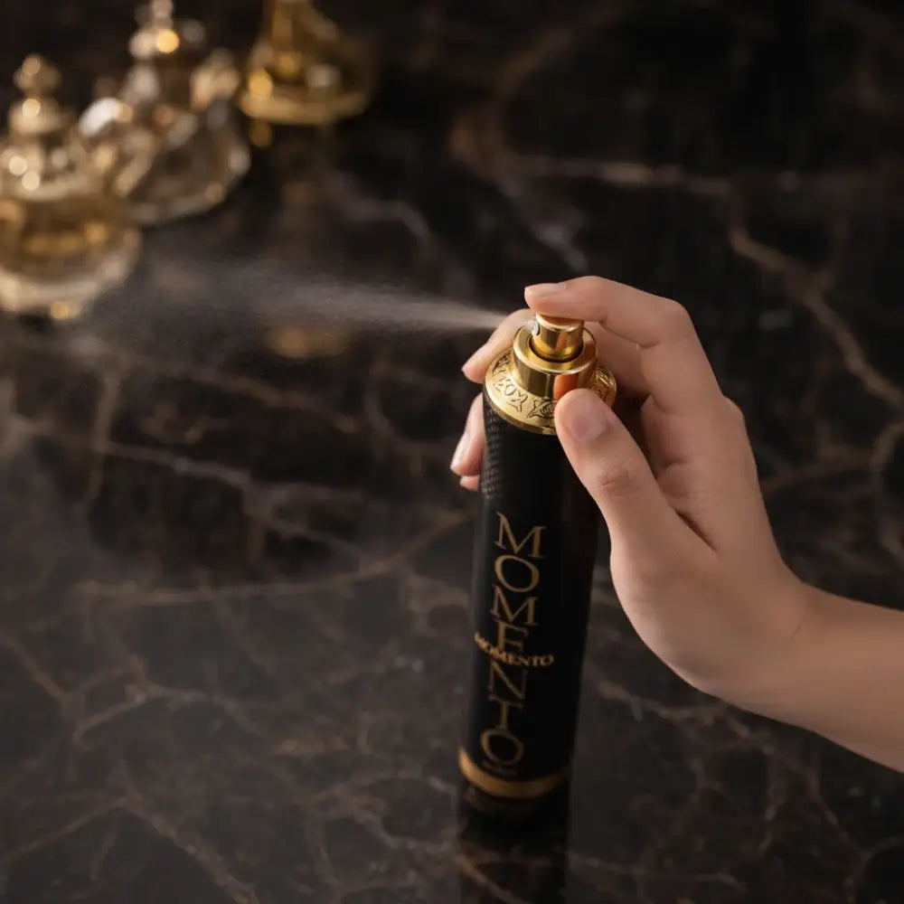 Hand holding a 'MOMENTO' hair spray can with a dark background
