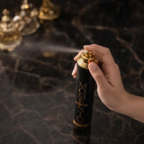 Hand holding a 'MOMENTO' hair spray can with a dark background