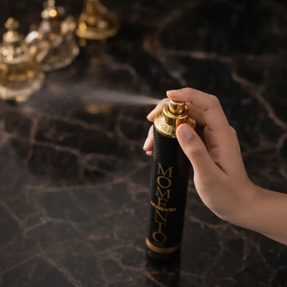 Hand holding a 'MOMENTO' hair spray can with a dark background