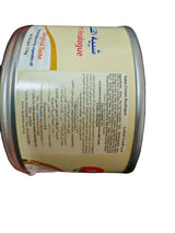 Hand holding a can of Unibene Evaporated Milk with visible text on the label.
