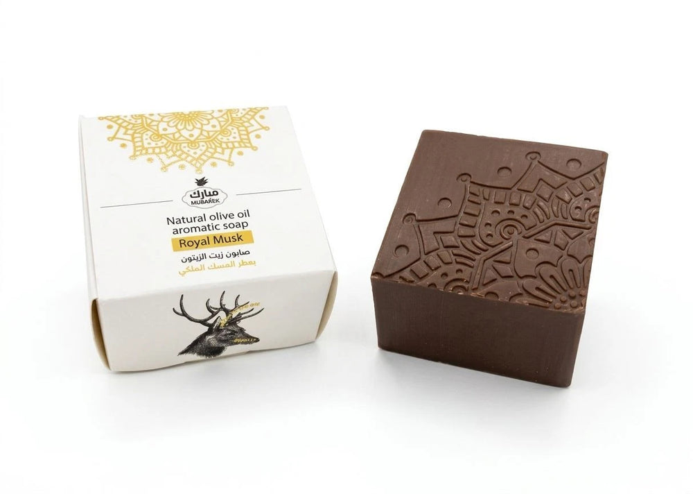Brown soap bar with decorative patterns next to its packaging on a white background