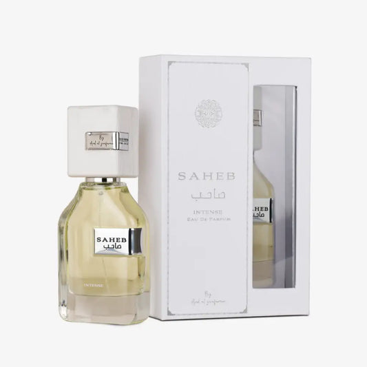 A sleek transparent glass bottle of saheb intense eau de parfum by ard al zaafaran with pale yellow liquid and white cap
