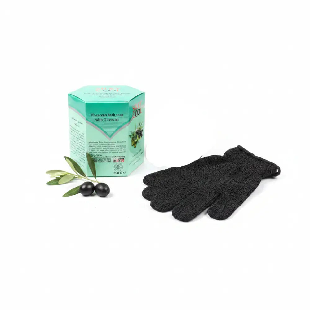 Box of Moroccan bath soap with olives oil held by a hand on a dark surface.