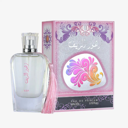 A clear glass perfume bottle with a silver cap and pink tassel labeled zahoor al reef by ard al zaafaran with ylang ylang